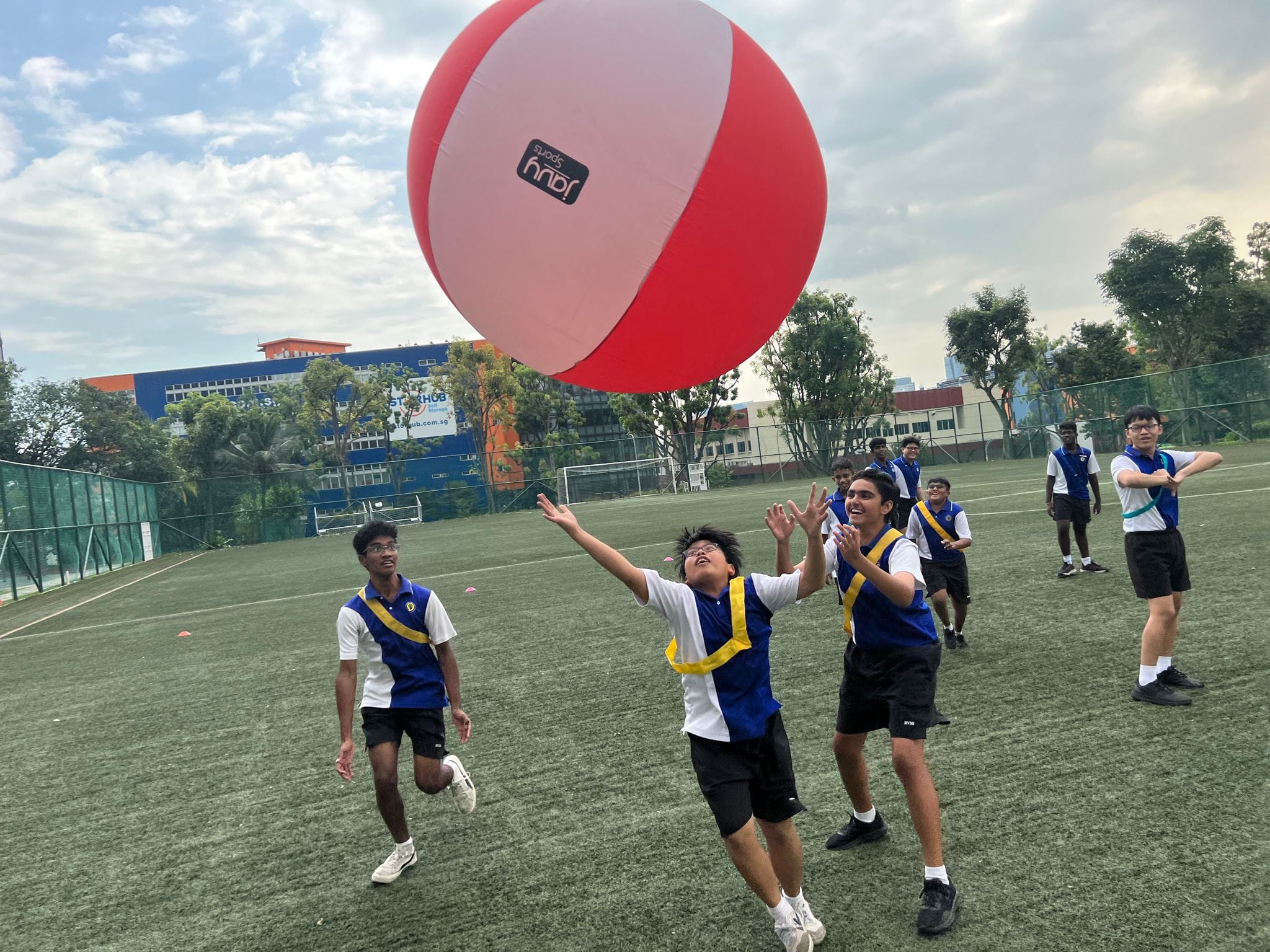 NCC cadets working together to keep a large Kin-Ball in play during an outdoor activity.